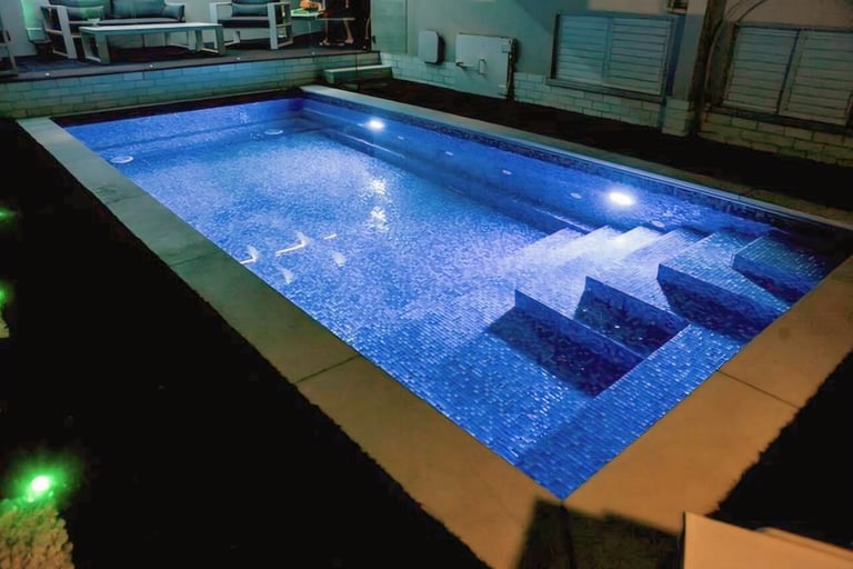 Foto kolam renang villa dengan suasana malam yang diterangi lampu taman