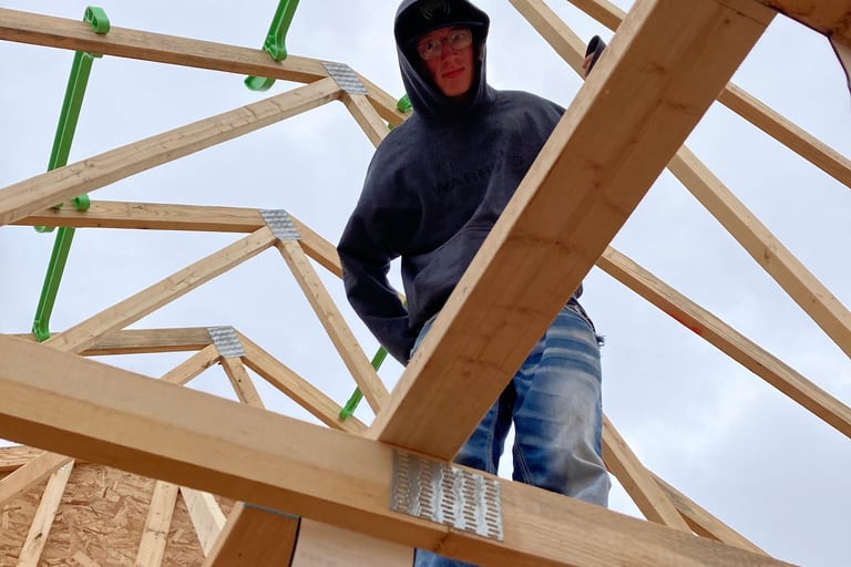 Man standing on roof trusses in Portage Wisconsin