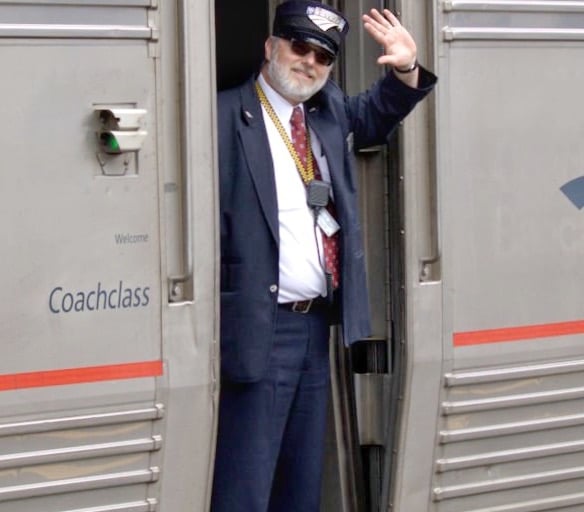 Amtrak train conductor waving from Empire Builder train in Portage Wisconsin. 
