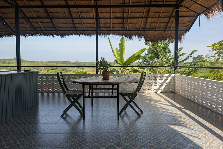 Open-air teahouse at Loei Valley with grass roof and orchard views