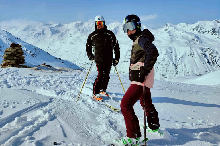 two people standing on skis in the snow
