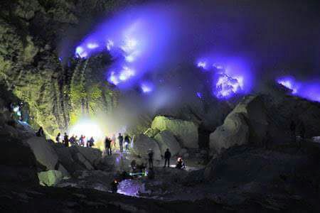 a group of people standing in front of blue flames