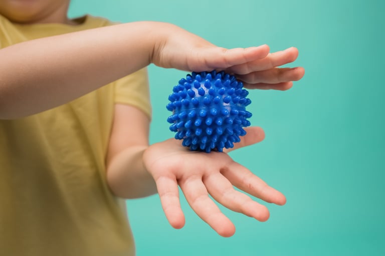 a child's hand holding a blue ball