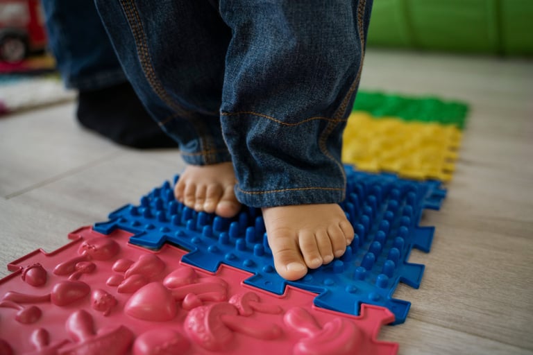 a child's feet on a mat with a toy