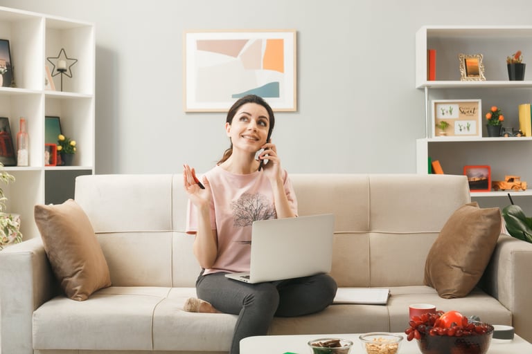a woman sitting on a couch talking on her cell phone
