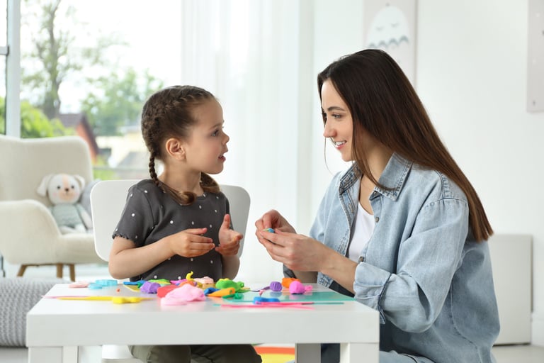 a woman sitting at a table with a little girl