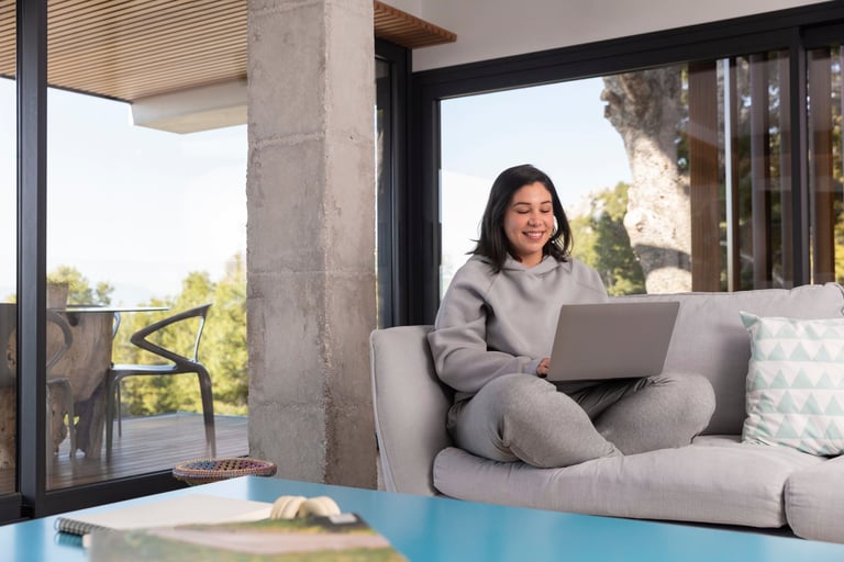 a woman sitting on a couch with a laptop computer