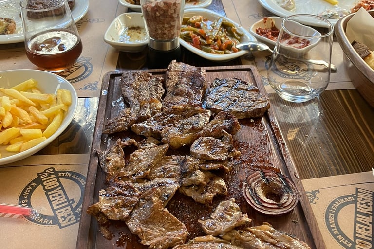 a table with a large wooden cutting board with steak and fries