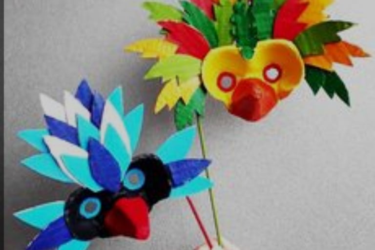 a person holding a paper flower with a bird on it