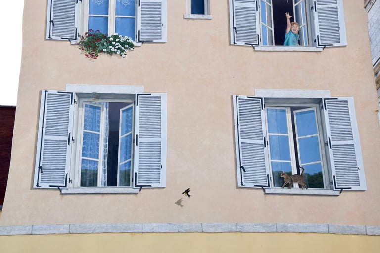 Deux fenêtres d'un étage en trompe-l'oeil sur une façade à Moirans-en-Montagne, dans le Jura.