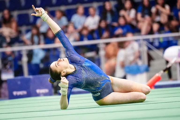Gymnast performing a floor routine pose at a competitive gymnastics event in Jesolo
