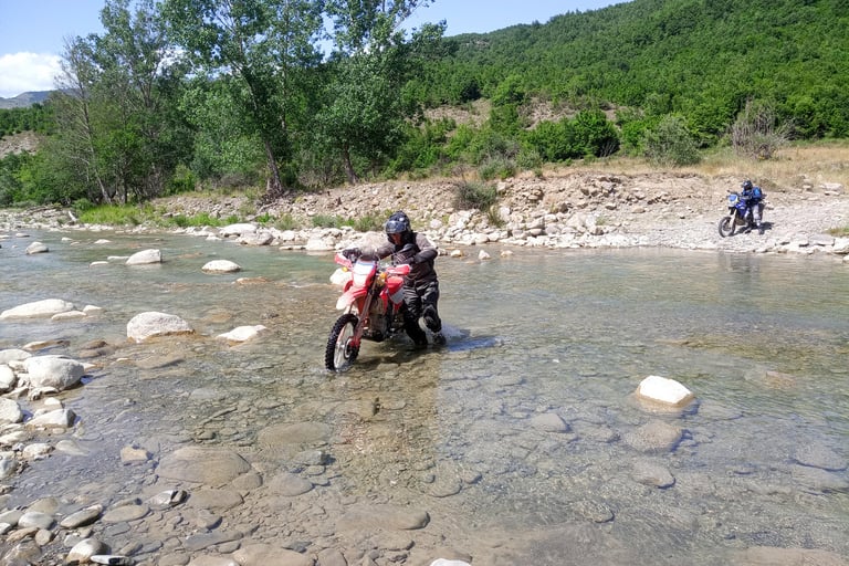 a person riding a motorcycle through a river