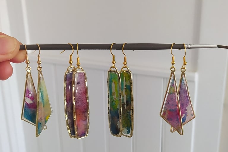 a person holding a string of jewelry with a bunch of colorful gems