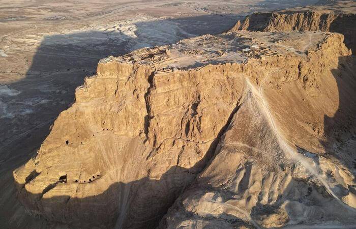 Aerial view of Masada fortress on a desert plateau overlooking the Dead Sea.