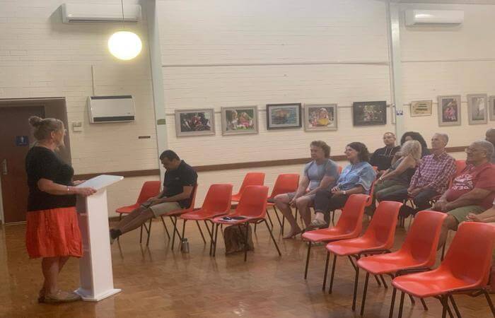 Salome speaking and teaching from a lectern to a seated church group.