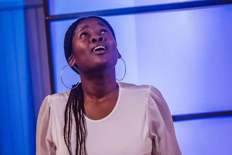 A woman looks upward in worship, expressing faith, hope, and a search for truth.