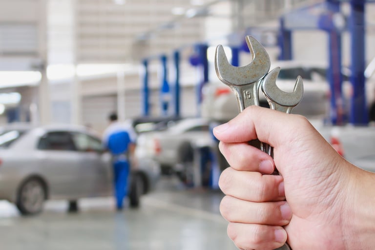 a person holding a wrenet in a garage