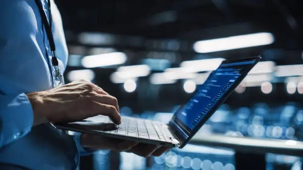 a man in a blue suit is holding a laptop