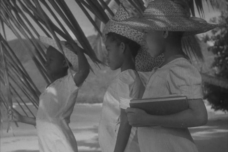 Black and white photo of three Mauritian children in straw hats by the beach, Cape Town Photography Festival 2025.