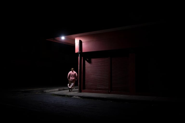 Person walking under streetlight at night in Mauritius, Cape Town Photography Festival 2025.