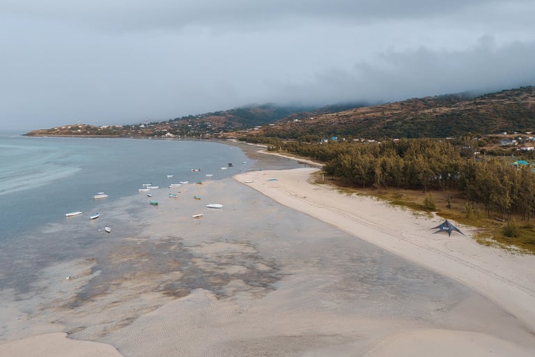 Aerial view of a peaceful beach on Rodrigues Island, with fishing boats anchored near the shore