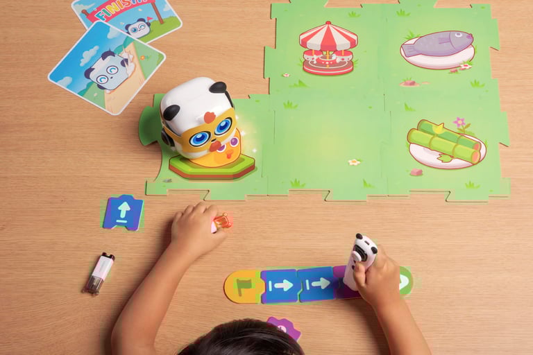 A young child plays with a colorful, screen-free robot on an interactive floor mat.