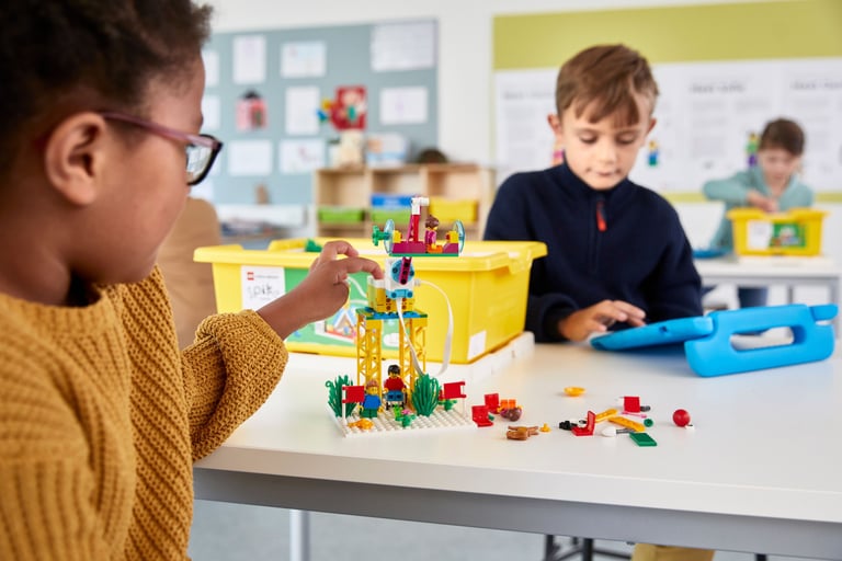 The SPIKE Essential robot kit with its white hub, motor, and collection of colorful LEGO bricks.