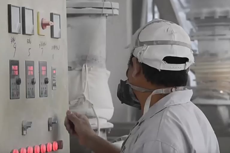 một người đàn ông mặc đồng phục màu trắng đang đeo mặt nạ và mặt nạ phòng độc