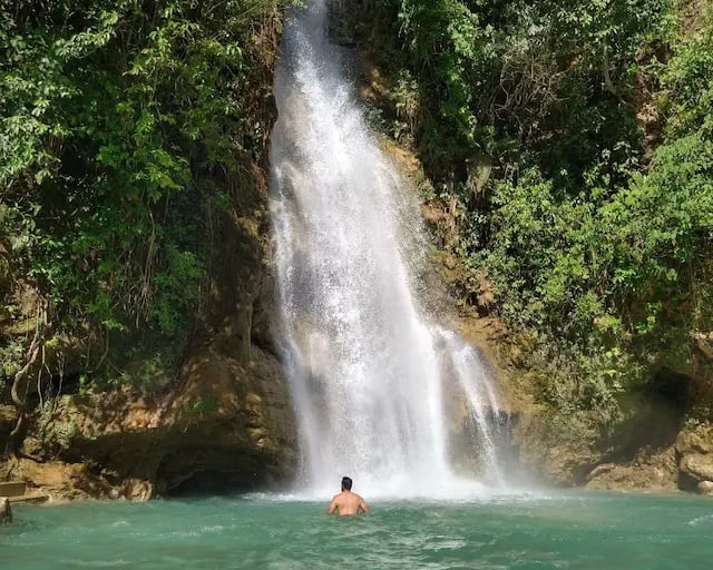 a man standing in front of a waterfall