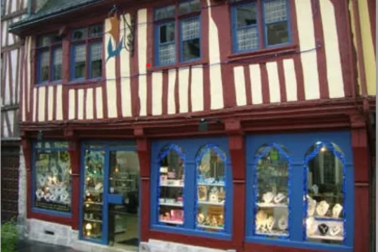 a store front of a building with a clock on the outside