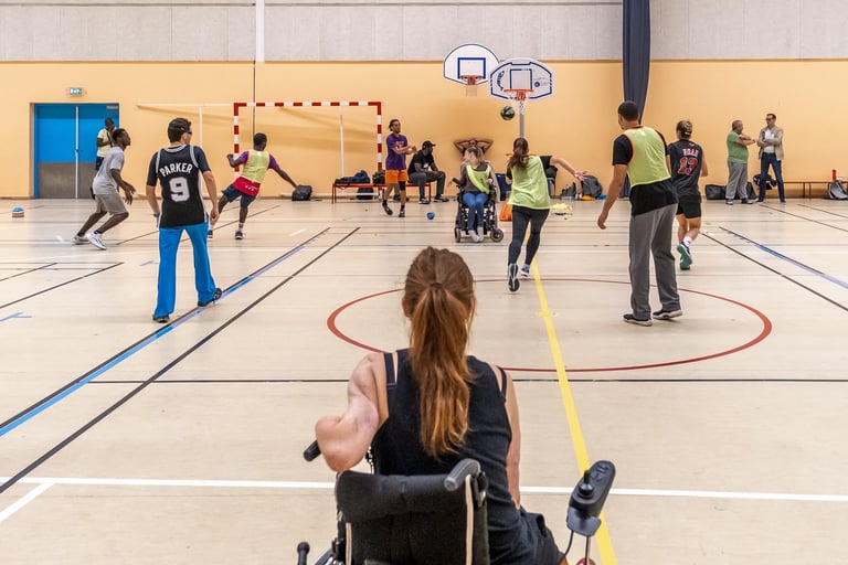Un terrain de basket avec de joueurs et un femme de dos