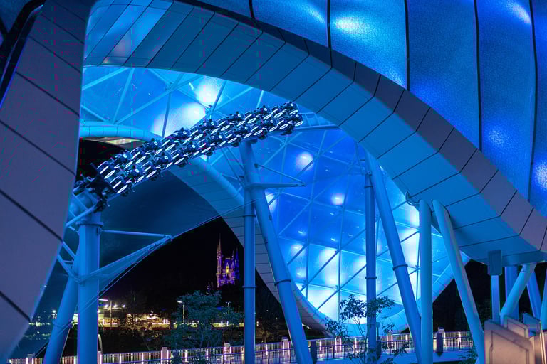 a roller coaster with a blue lit canopy background