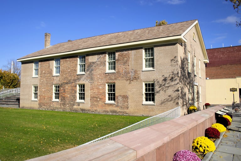 a brick building with a fenced in area with flowers