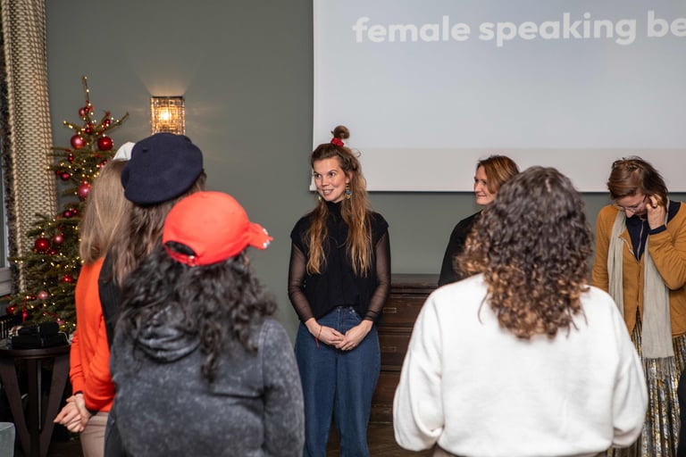 Women looking at female public speaking trainer, beamer in back showing: female speaking berlin