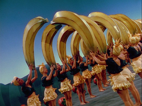 Technicolor chorus girls holding oversized bananas in arch formation from The Gang’s All Here (1943)