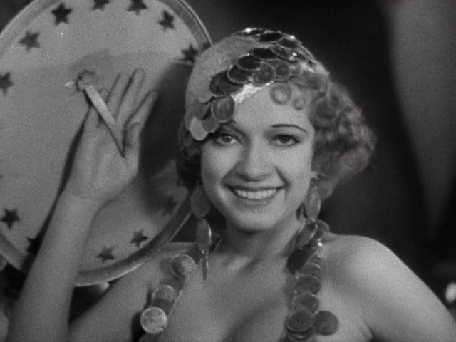 Chorus girl revealing her face from behind a large prop in Busby Berkeley’s classic “parade of faces