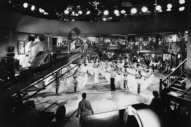 Busby Berkeley on a high crane camera rig, looking down at dancers holding skirts in geometric form