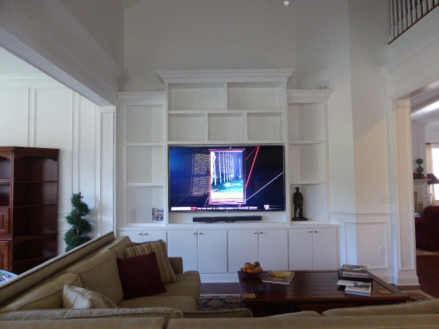 Custom white built-in media wall with bookcases and cabinetry in a Monmouth County home