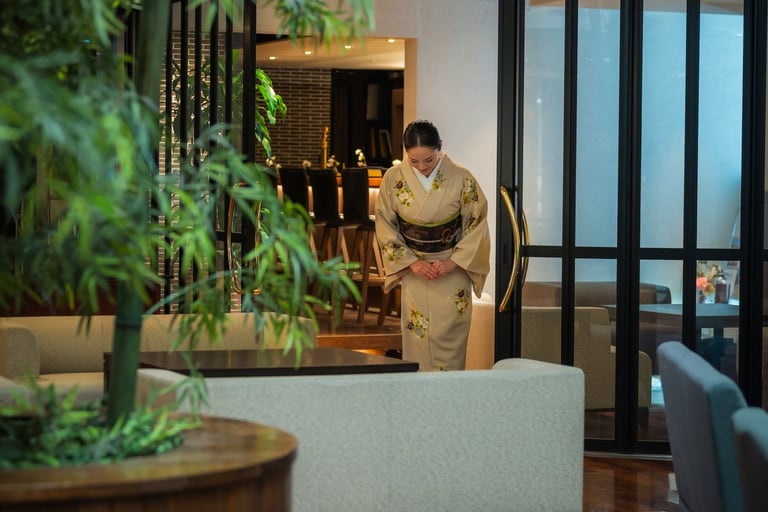 a woman dressed in kimono greeting customers from the lobby of the chaharu hotel