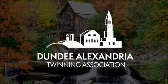 Dundee Alexandria Twinning Association logo over a scenic waterfall and historic rustic grist mill in autumn.