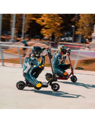 two people riding scooters on a skateboard