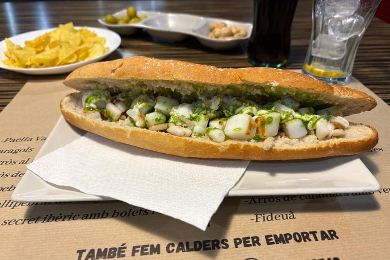Grilled cuttlefish baguette sandwich with garlic and parsley sauce, served with olives and chips.