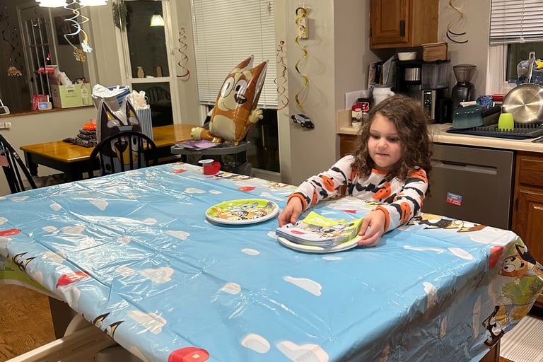 big sister helping decorate for siblings birthday party tradition