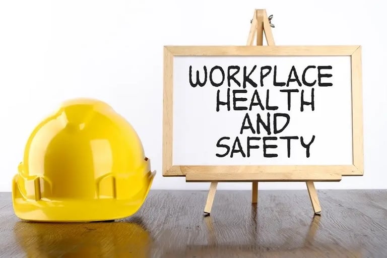 Yellow hard hat next to a sign that says Workplace Health and Safety on a wooden desk.