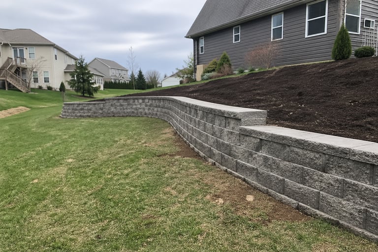 retaining wall installation in Grand Rapids, MI backyard with natural slope by Garcia’s Landscaping 