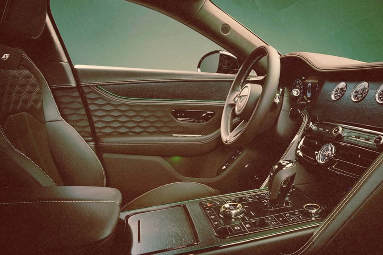 Luxury car interior with quilted leather seats and a digital dashboard display.