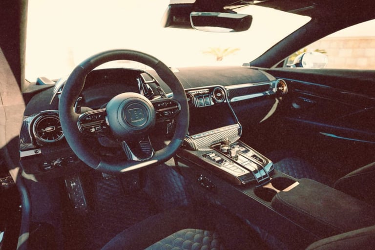 Luxury Brabus car interior featuring a carbon fiber dashboard, Alcantara steering wheel, and premium leather seats.