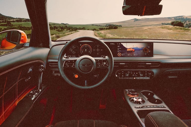 Modern luxury car interior with a digital dashboard and steering wheel overlooking a scenic road.