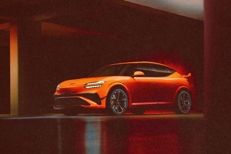Orange Genesis GV60 Magma concept electric SUV parked in a dimly lit modern garage.