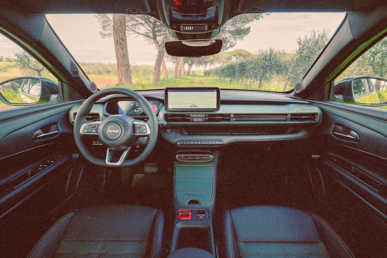 Interior view of a modern Jeep Avenger electric SUV dashboard with digital cockpit and infotainment system.